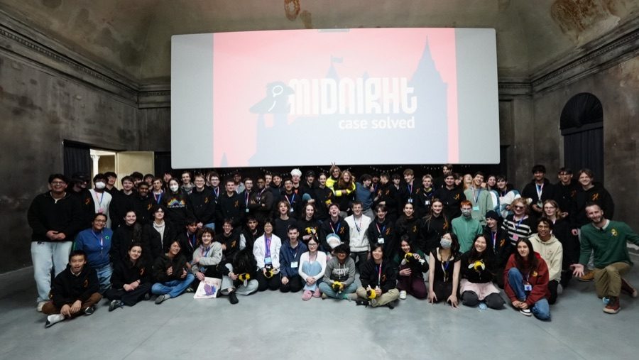 About a hundred teenagers in a group photo under a big screen at Hack Club's Midnight event
